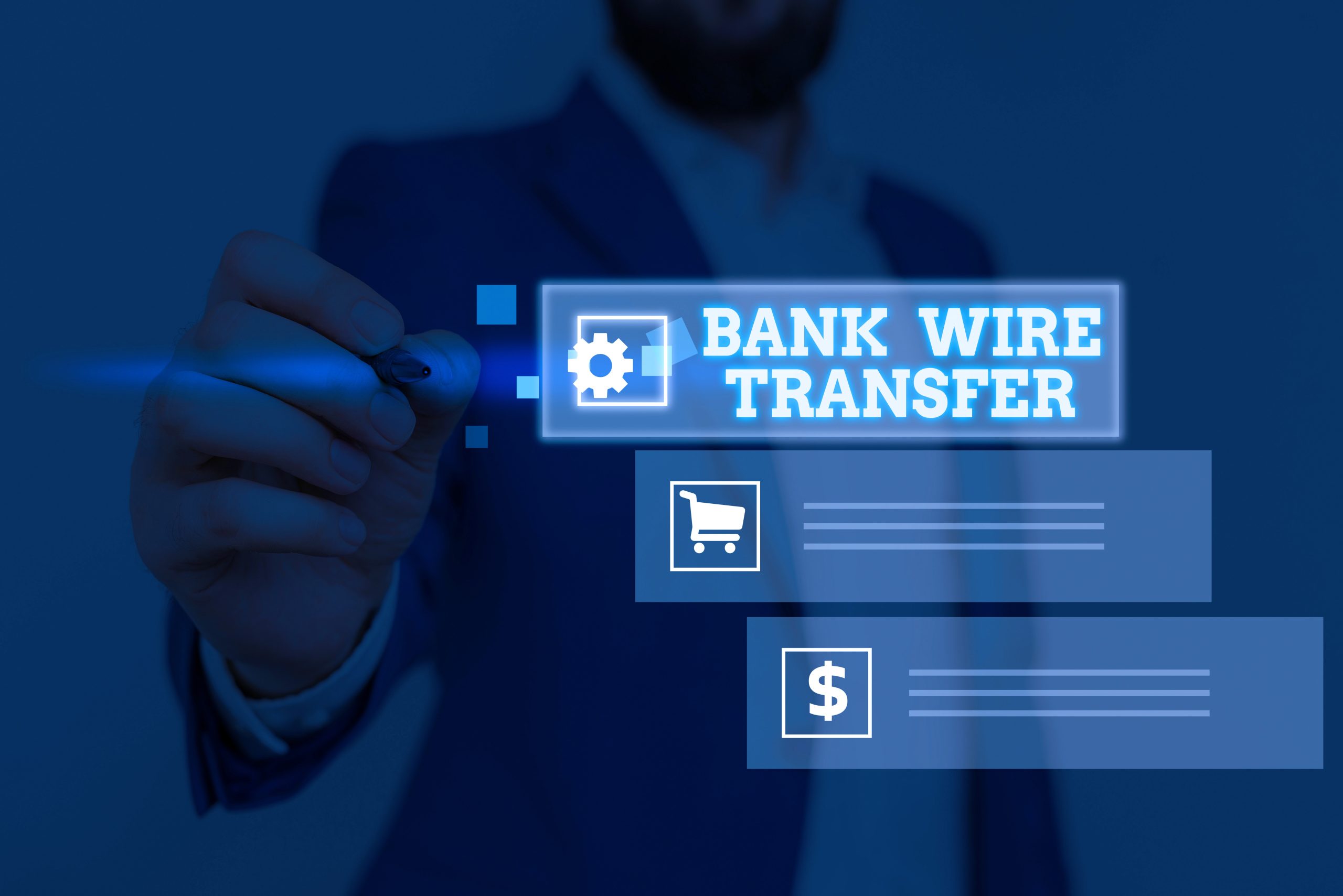 Stock image of a business person holding a pen pointing to some text reading "bank wire transfer"